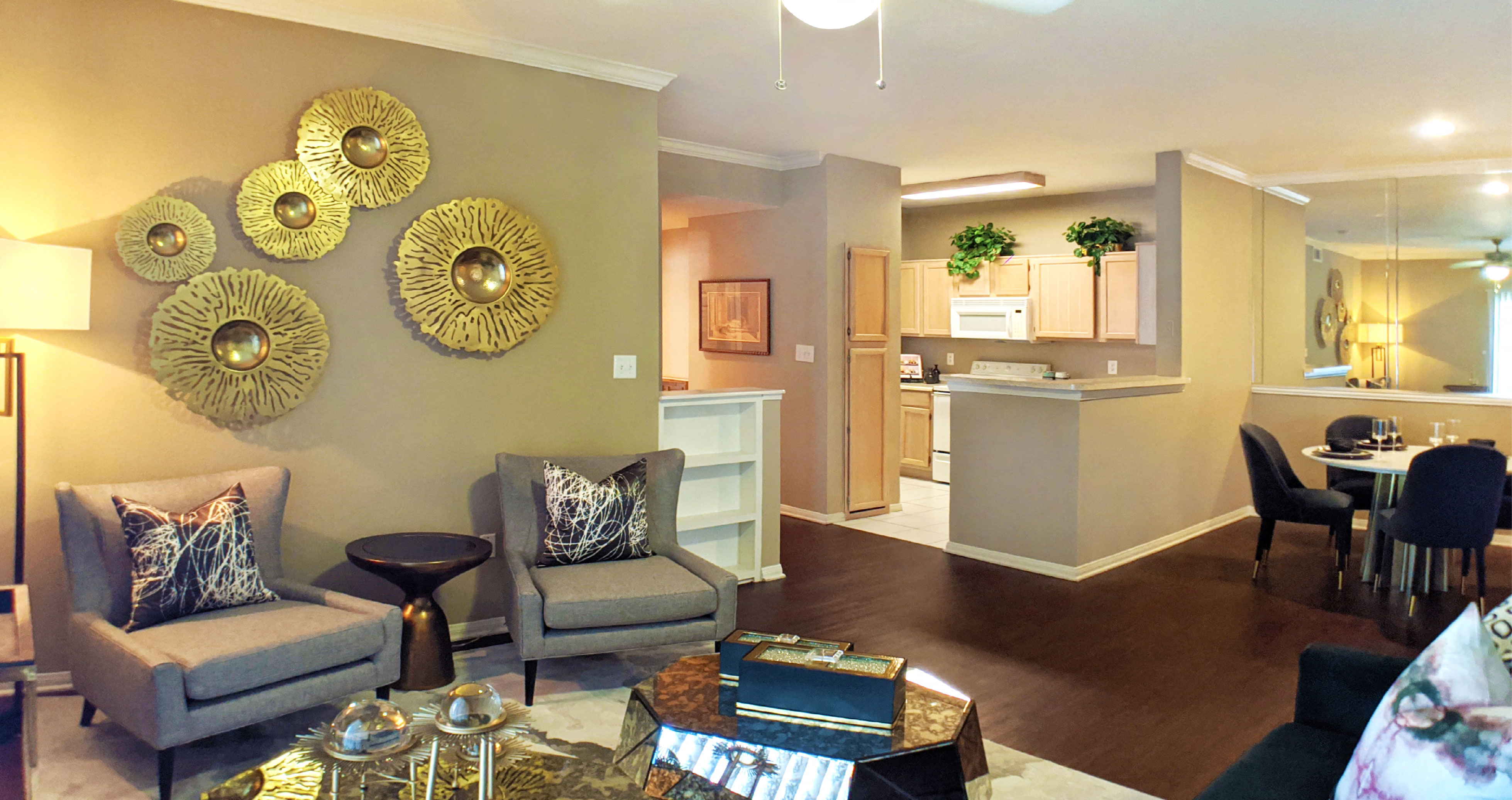 Luxury apartments with spacious kitchen, full-size washer and dryer, wood plank floors, built-in shelves, breakfast bar, mirror accent wall, washed oak cabinets, and 9-foot ceilings at Kensington Square Apartments.